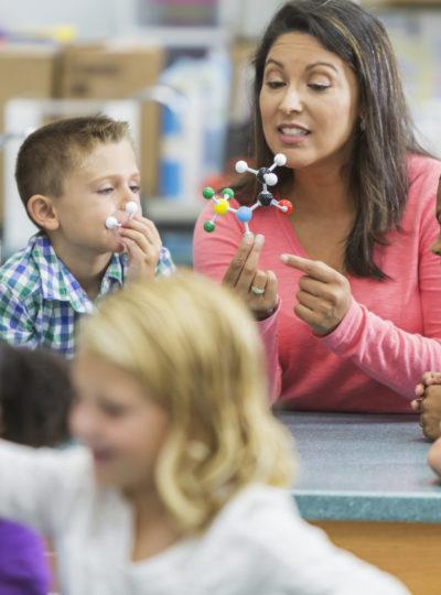 Young woman teaches elementary students about science